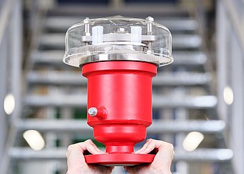 Zwei Hände halten Flammschutzarmatur vor Treppe