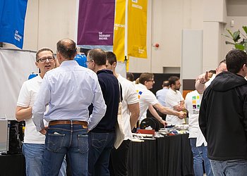 Messestand mit Besuchern am Tag der Technik von HENNLICH