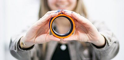 Simone Rakaseder hält Hydraulikdichtung in beiden Händen | HENNLICH