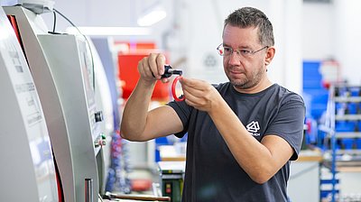 Alexander Pucher, CNC-Dreher bei HENNLICH, bei der Arbeit an einer CNC-Maschine