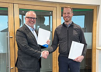 Robert Angel von SMC und und Markus Zebisch von HENNLICH Global bei der Vertragsunterzeichnung in Suben.