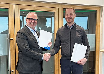 Robert Angel von SMC und und Markus Zebisch von HENNLICH Global bei der Vertragsunterzeichnung in Suben.